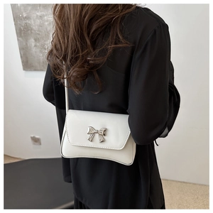 Détail d'un sac baguette en cuir verni blanc avec une boucle en métal argenté
