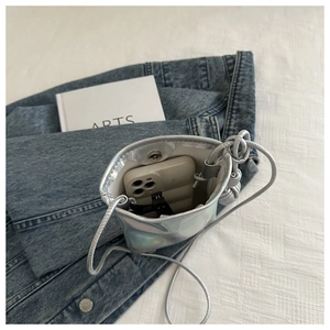 Détail du sac à bandoulière argenté laser avec bouton aimanté et espace intérieur