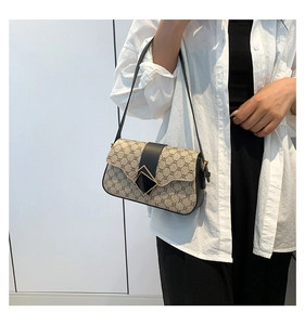 Détail d'un sac à bandoulière monogramme kaki avec rabat noir et fermoir métallique en losange