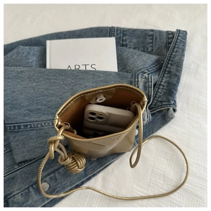 Détail de la pochette téléphone dorée montrant la capacité avec un smartphone à l'intérieur