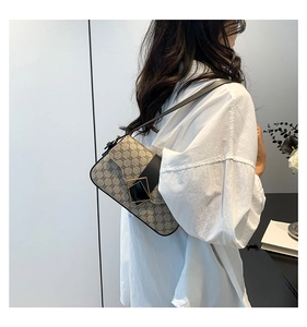 Détail du sac à bandoulière monogramme vintage avec boucle dorée et lanière en cuir