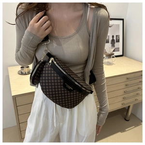 Detail of vintage geometric brown chest bag with leather trim and gold hardware accents