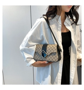 Détail du sac sous le bras au motif vintage avec bandoulière et boucle en cuir noir