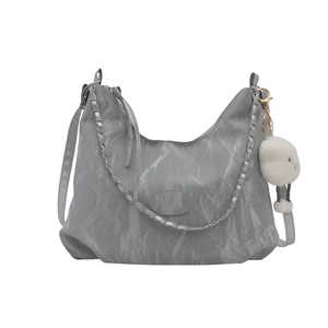 Gray pleated shoulder bag with chain detail and plush cloud charm on white background