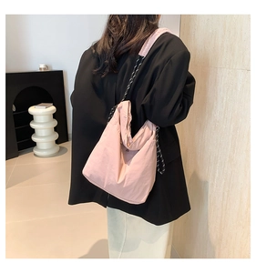 Detail of light pink tote bag with striped rope strap and magnetic buckle closure