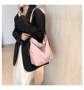 Pink nylon hobo bag featuring adjustable woven contrast rope straps for daily commute