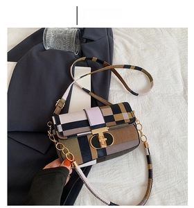 Détail du sac à rabat en patchwork bicolore avec boucle en métal doré en forme de T