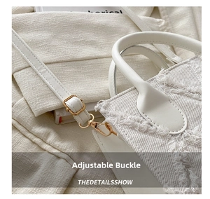 Detail of frayed edge canvas tote bag with gold metal buckle and woven strap texture