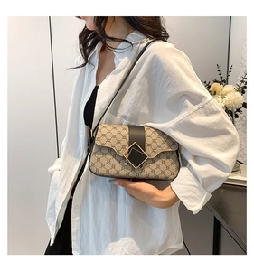 Vue détaillée du sac porté épaule vintage beige avec bordure noire et boucle dorée