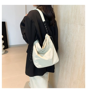 Close-up of stylish off-white tote bag with black and white rope strap detail
