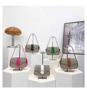 Vue détaillée des sacs sous l'aisselle à monogramme en cinq coloris sur socle géométrique