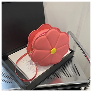 Detail shot of a 3D pink flower shaped crossbody bag on a luxury display box