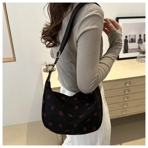 Black corduroy hobo bag with red strawberry embroidery and wide shoulder strap