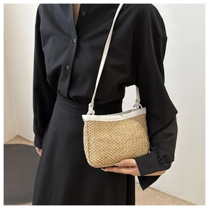 Detailed close-up of handmade straw shoulder bag with white leather trim and strap