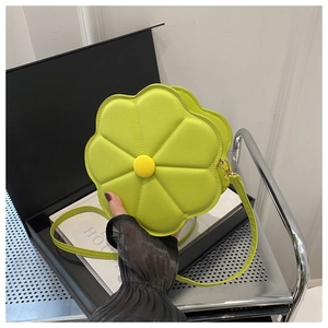 Detailed macro view of green flower-shaped leather bag with yellow center and fine strap
