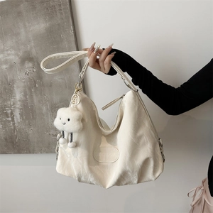 White nylon tote bag with soft texture and cute cloud charm held by a model