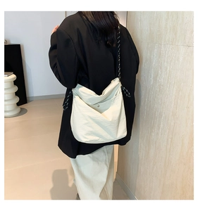 Detail of minimalist beige tote bag with a unique black and white woven rope shoulder strap