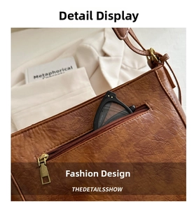 Detail of vintage brown tote bag showing textured leather and functional back zipper pocket