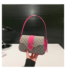 Détail du sac baguette en toile imprimée avec finitions en cuir rose et boucle dorée carrée