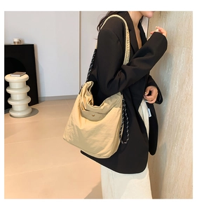 Detail of khaki tote bag with striped rope shoulder strap and metal buckle adjustment