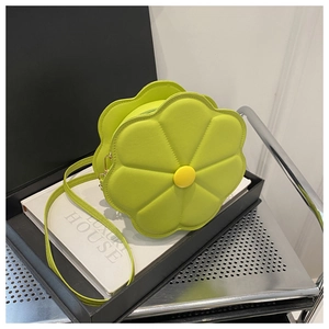 Detail view of flower-shaped lime green crossbody bag with yellow center button and PU leather
