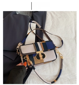 Détail du motif géométrique tricolore et du fermoir en métal doré sur le sac à rabat