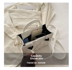 Top view of white denim tassel tote bag showing its large interior capacity and items