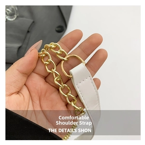Detailed macro view of white leather shoulder strap and thick golden metal chain links