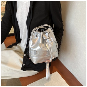 Detail of silver metallic drawstring bucket bag featuring cute 3D heart-shaped appliqués