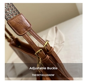 Detail of adjustable shoulder strap with gold metal buckle on vintage brown leather tote bag