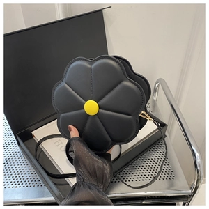 Detail view of the black flower petal shoulder bag with yellow floral stamen decoration