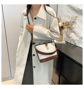 Model wearing a brown and white crocodile pattern bucket bag with adjustable crossbody strap