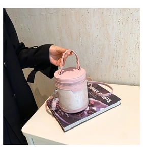 Detailed view of a pink bucket bag with floral embroidery and detachable strap