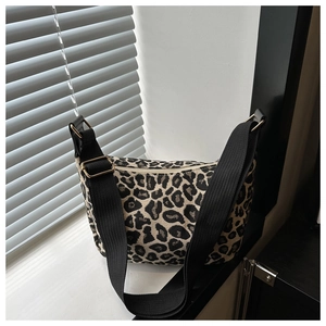Detail of leopard print handbag showing leopard pattern and black nylon shoulder strap