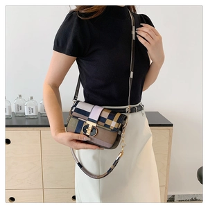 Vue latérale d'une femme portant un sac bandoulière à carreaux et boucle dorée