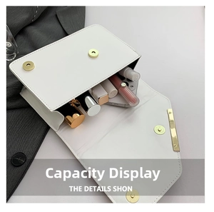 Detail of white leather envelope bag interior showing capacity for cosmetics and gold hardware