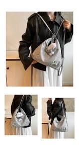 Détail du sac hobo argenté avec papillons 3D et un pendentif nuage en peluche doux