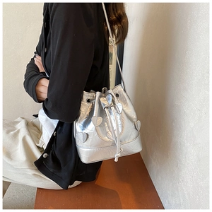 Detail of silver drawstring bucket bag featuring unique 3D heart-shaped floral appliqués