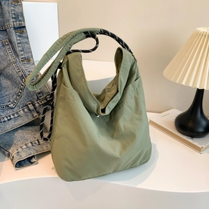 Chic light green nylon tote bag with braided rope strap shown in lifestyle setting