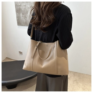 Detailed back view of a large khaki tote bag with silver studs and adjustable shoulder strap