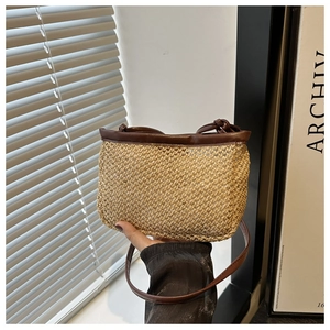 Chic woven straw shoulder bag with dark brown leather trim for casual beach style
