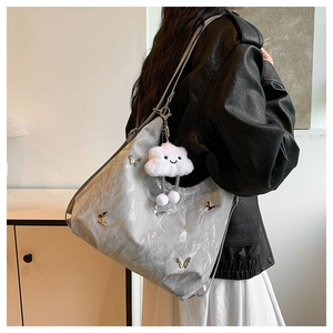 Détail du cabas métallisé argenté avec papillons et pendentif peluche en forme de nuage