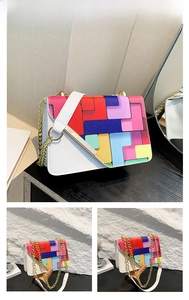 Détail du motif géométrique coloré et de la chaîne dorée sur le sac bandoulière blanc