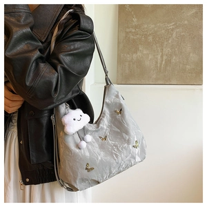 Sac hobo gris argenté plissé orné de papillons dorés et d'un charmant nuage en peluche