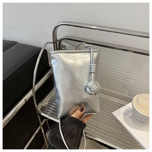 Détail du sac à bandoulière en cuir argenté froissé avec bandoulière à nœud tressé
