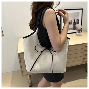 Modern large herringbone canvas tote bag with black bow detail shown on shoulder