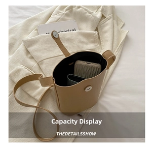Internal view showing storage capacity for phone and wallet in khaki leather bucket bag