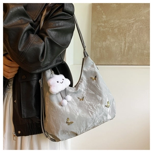 Détail du sac à bandoulière argenté avec papillons dorés et breloque petit nuage