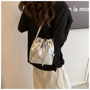 Detail of silver drawstring bucket bag with metallic heart appliques and pleated texture