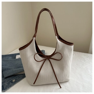 Détail macro du sac cabas en toile à chevrons avec des finitions en cuir marron chic